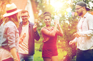 Image showing happy friends dancing at summer party in garden