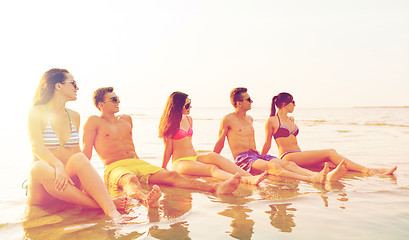 Image showing smiling friends in sunglasses on summer beach