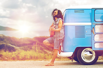 Image showing hippie man playing guitar at minivan car on island