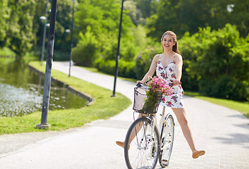 Image showing happy woman riding fixie bicycle in summer park