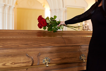 Image showing woman with red roses and coffin at funeral