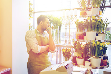 Image showing sad florist man or seller at flower shop counter