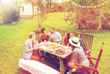 Image showing happy friends having dinner at summer garden party