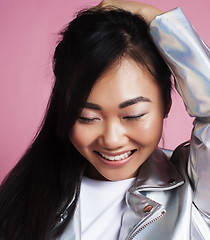 Image showing young pretty smiling asian korean girl wearing modern fashion clothers on pink background, lifestyle people concept