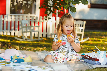 Image showing The little girl sitting on green grass