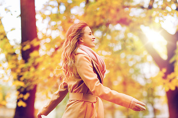 Image showing beautiful happy young woman walking in autumn park