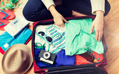 Image showing close up of woman packing travel bag for vacation