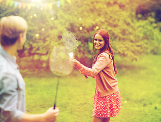 Image showing happy friends playing badminton at summer garden