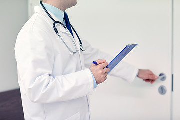 Image showing close up of doctor with clipboard at hospital door