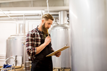 Image showing man with clipboard at craft brewery or beer plant