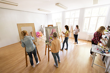 Image showing woman artists with brushes painting at art school