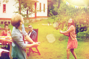 Image showing happy friends playing badminton at summer garden