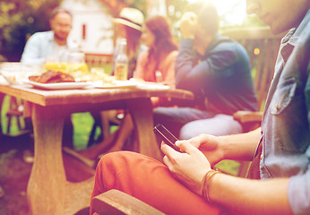 Image showing man with smartphone and friends at summer party