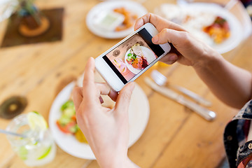 Image showing hands with smartphone picturing food at restaurant