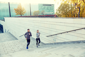 Image showing happy couple running upstairs on city stairs