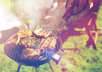 Image showing man cooking meat on barbecue grill at summer party