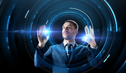 Image showing businessman with virtual projection over black