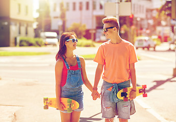 Image showing teenage couple with skateboards on city street