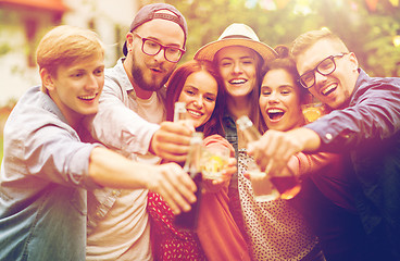 Image showing happy friends clinking glasses at summer garden