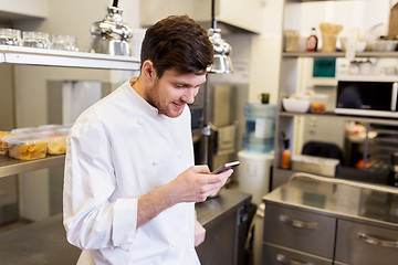 Image showing chef cook with smartphone at restaurant kitchen