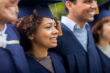 Image showing happy students or bachelors in mortar boards