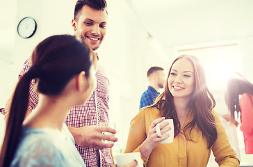 Image showing happy creative team drinking coffee at office