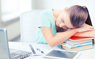 Image showing tired student sleeping on stock of books