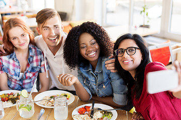 Image showing friends eating and taking selfie at restaurant