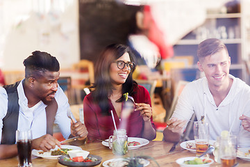 Image showing happy friends eating at restaurant