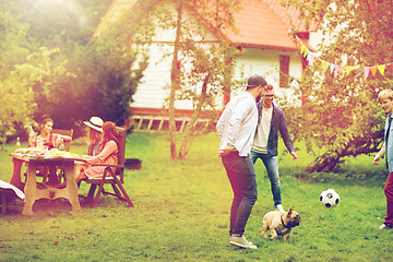 Image showing friends playing football with dog at summer garden