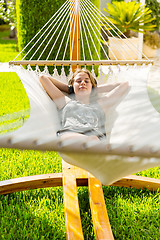 Image showing Girl relaxing and listening to music in hammock