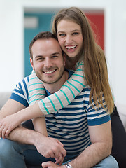 Image showing young handsome couple hugging on the sofa