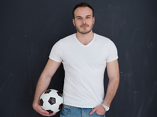 Image showing man playing with soccer ball isolated over grey