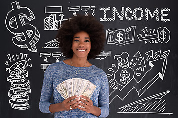 Image showing black woman holding money on gray background