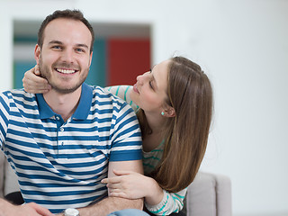 Image showing young handsome couple hugging on the sofa