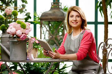 Image showing Florist with tablet with flowers