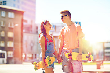 Image showing teenage couple with skateboards on city street