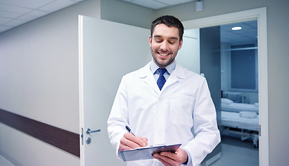 Image showing smiling doctor with clipboard at hospital