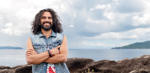 Image showing smiling hippie man in denim vest on island