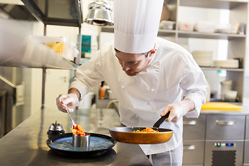 Image showing happy male chef cooking food at restaurant kitchen