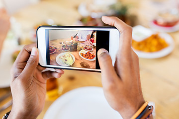 Image showing hands with smartphone picturing food at restaurant