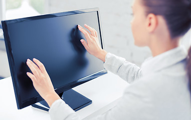 Image showing smiling businesswoman with touchscreen in office