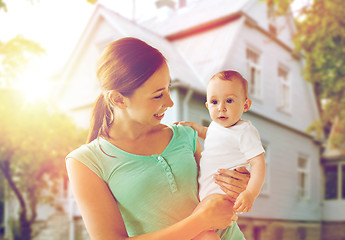 Image showing happy young mother with baby over holidays lights