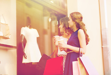 Image showing young women with shopping bags and coffee at shop