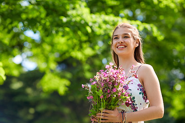 Image showing happy young woman with flowers in summer park