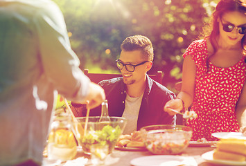 Image showing happy friends having dinner at summer garden party