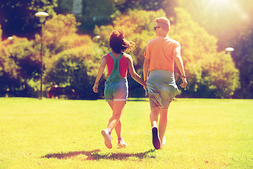 Image showing happy teenage couple walking at summer park