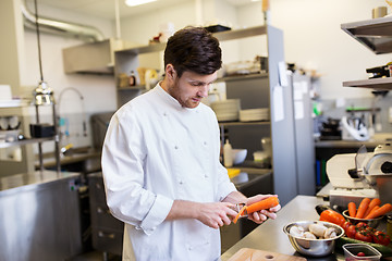 Image showing happy male chef cooking food at restaurant kitchen