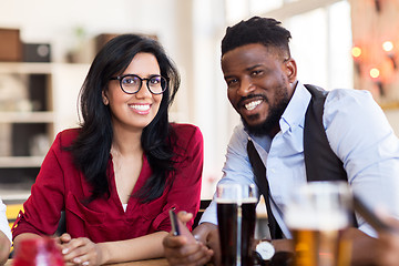 Image showing happy man and woman with smartphone at bar