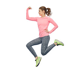 Image showing happy smiling sporty young woman jumping in air